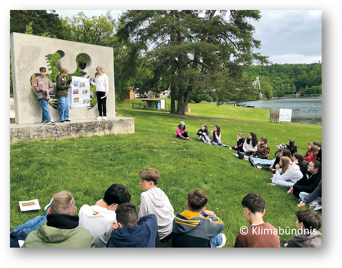 Schüler sitzen auf Wiese